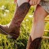 woman putting on Western boots