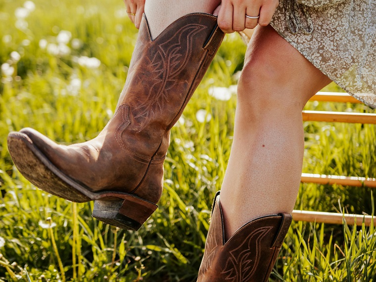 woman putting on Western boots